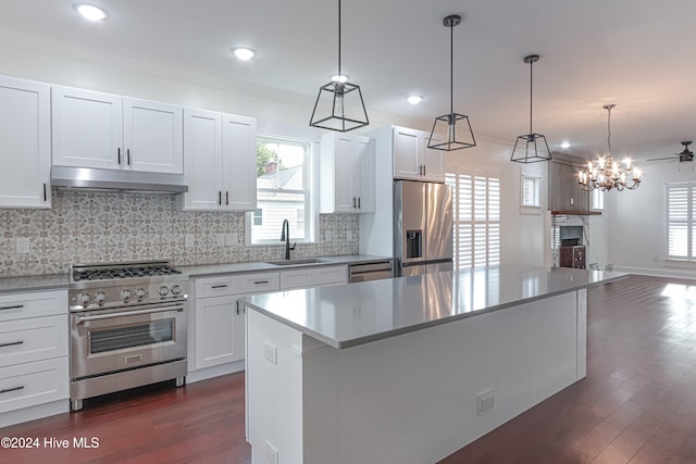 kitchen with appliances with stainless steel finishes, ceiling fan, pendant lighting, a center island, and white cabinetry