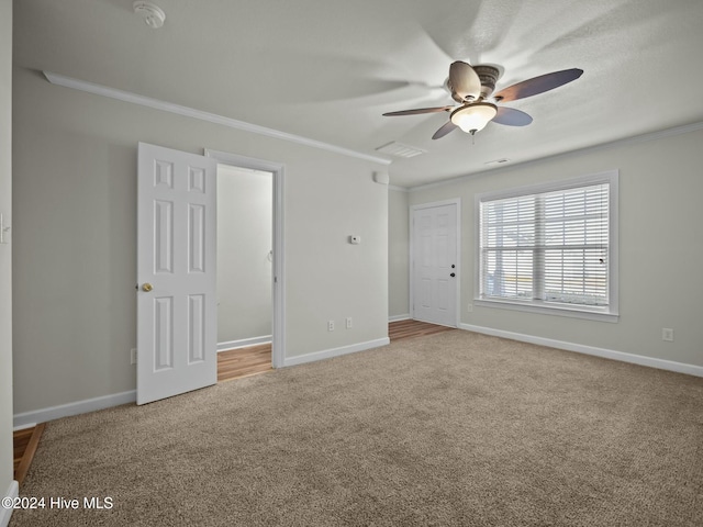 unfurnished bedroom with carpet flooring, ceiling fan, and crown molding