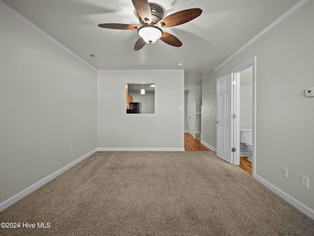 spare room with ceiling fan, ornamental molding, and light carpet