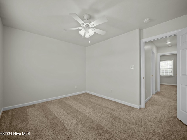 empty room with ceiling fan and light colored carpet