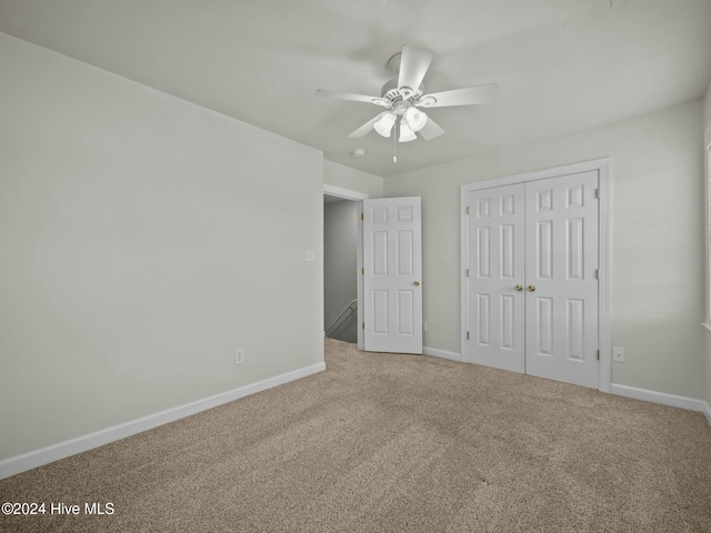 unfurnished bedroom with carpet flooring, ceiling fan, and a closet