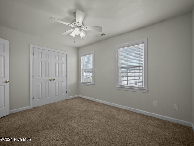 unfurnished bedroom featuring carpet flooring, ceiling fan, and a closet