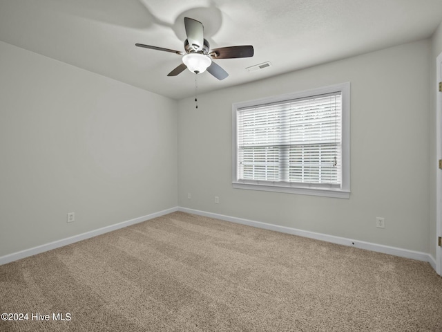 carpeted spare room featuring ceiling fan