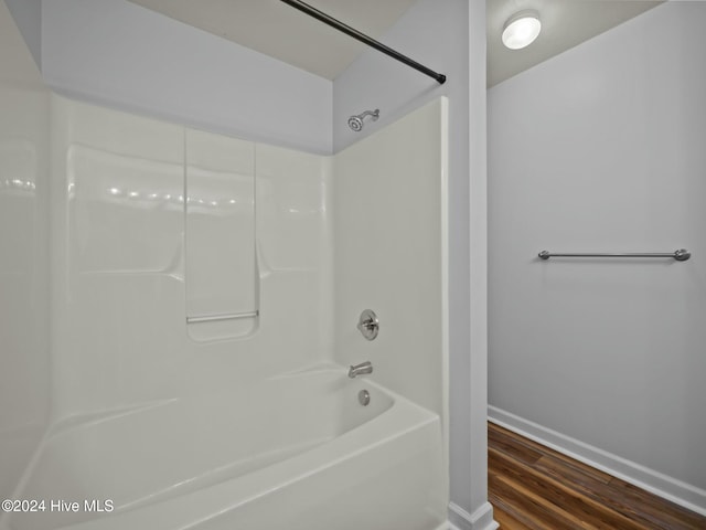 bathroom featuring wood-type flooring and bathtub / shower combination