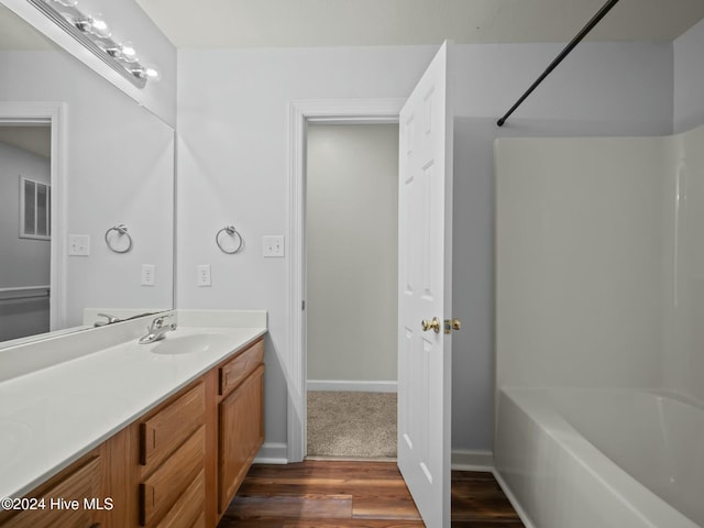 bathroom with hardwood / wood-style floors, vanity, and  shower combination