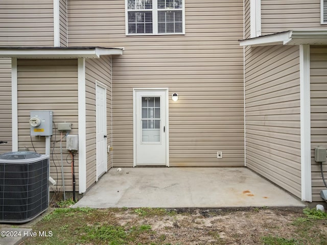 entrance to property featuring a patio and cooling unit