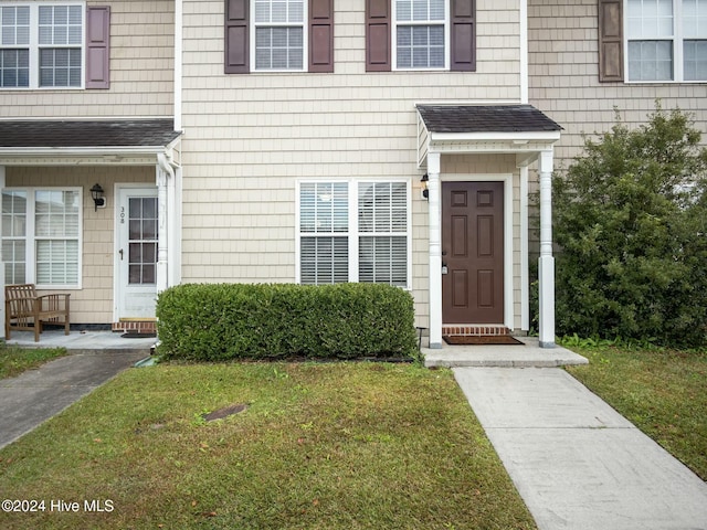 view of exterior entry with a lawn