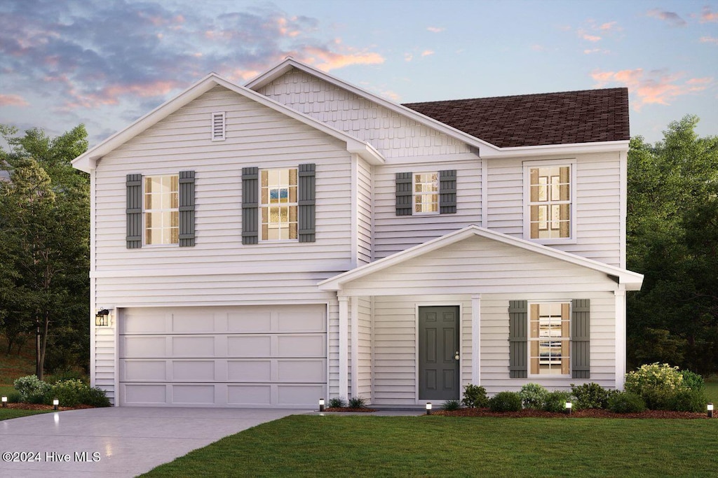 view of front facade with a lawn and a garage