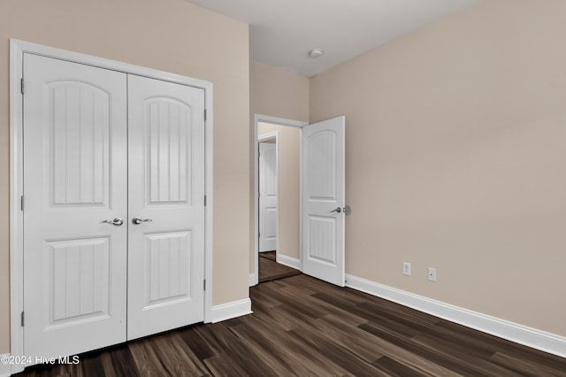 unfurnished bedroom featuring dark hardwood / wood-style floors and a closet