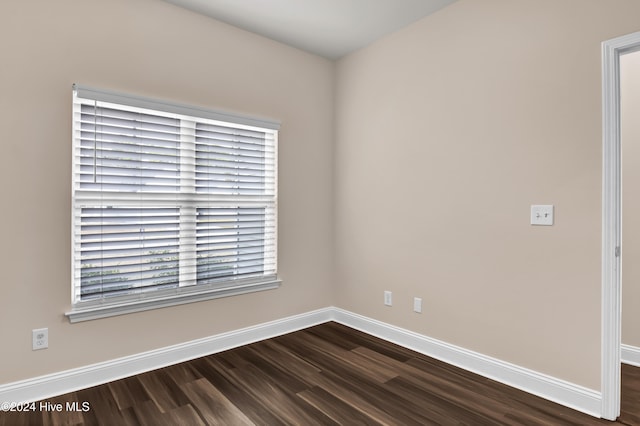 unfurnished room with dark wood-type flooring