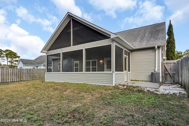 back of house featuring a sunroom and a yard