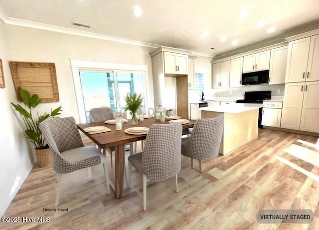 dining space with recessed lighting, light wood-type flooring, visible vents, and crown molding