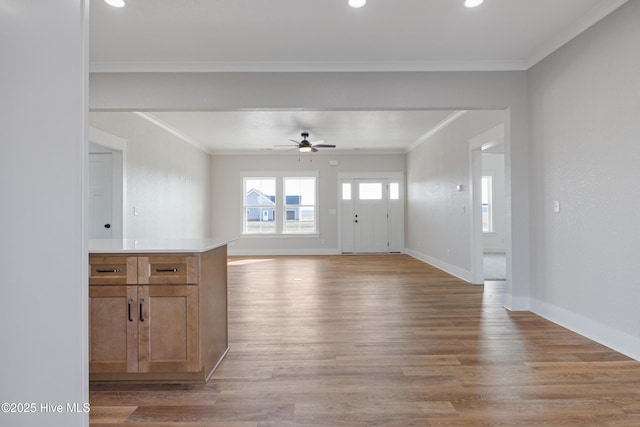 unfurnished living room with crown molding, light wood-style flooring, and baseboards