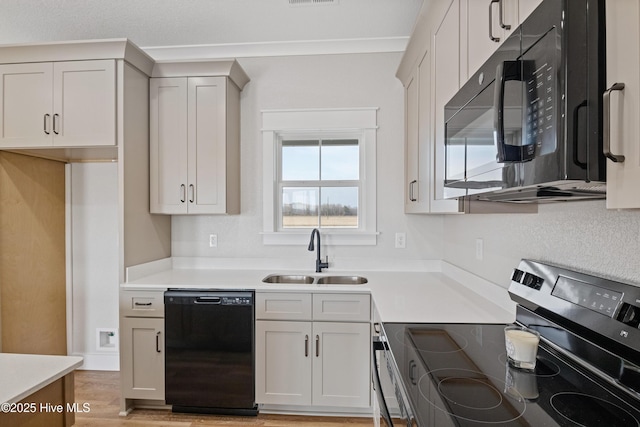 kitchen featuring visible vents, light countertops, crown molding, black appliances, and a sink