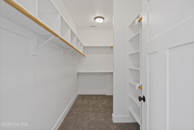 walk in closet with visible vents and dark carpet