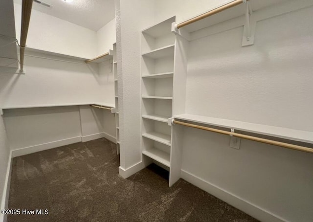 walk in closet with dark colored carpet and visible vents