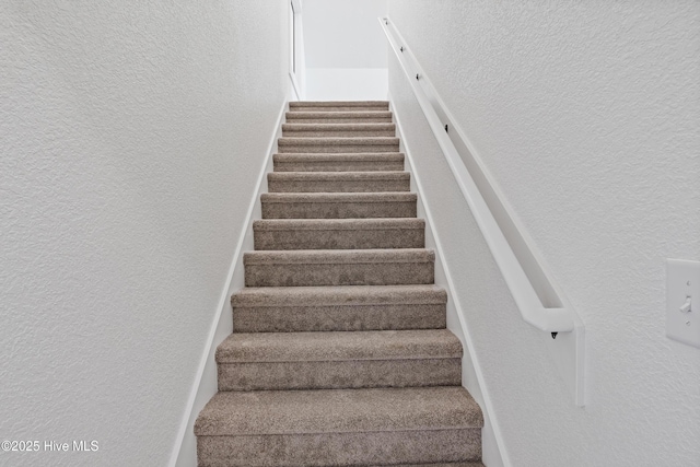 stairs featuring a textured wall