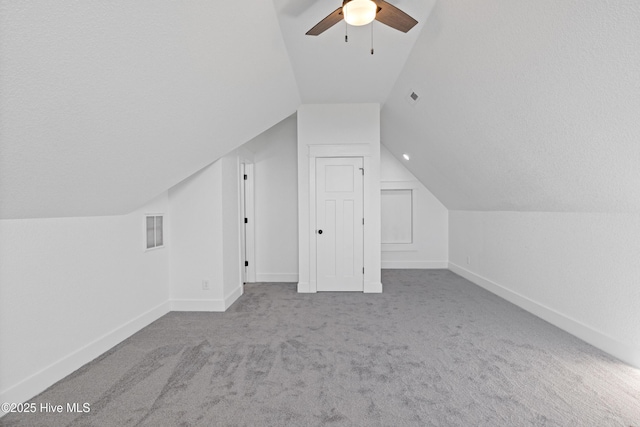 additional living space featuring a ceiling fan, lofted ceiling, visible vents, and baseboards