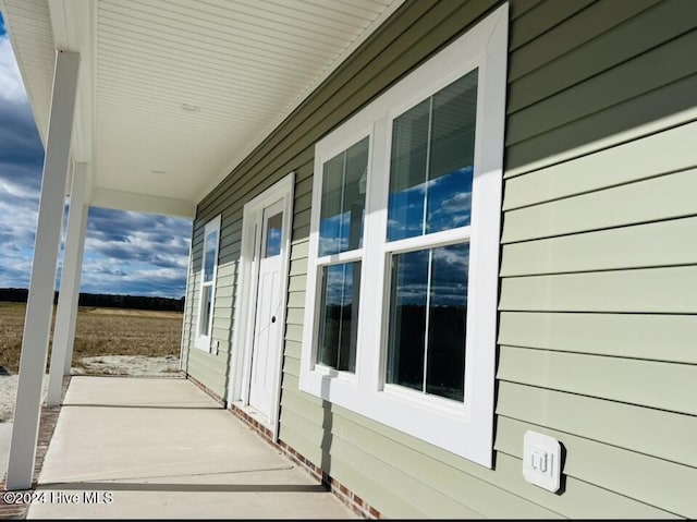 view of side of home featuring covered porch