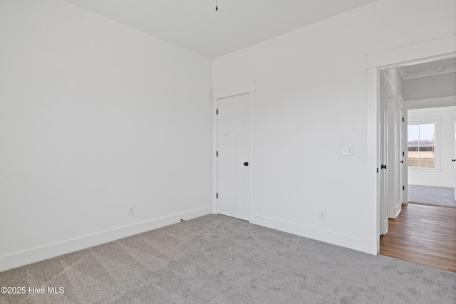 unfurnished room featuring carpet and baseboards