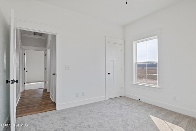 unfurnished bedroom with baseboards, visible vents, and carpet flooring