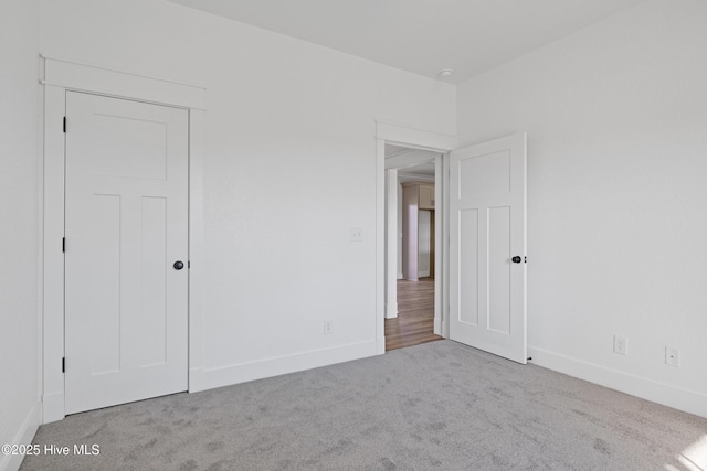 unfurnished bedroom featuring carpet and baseboards