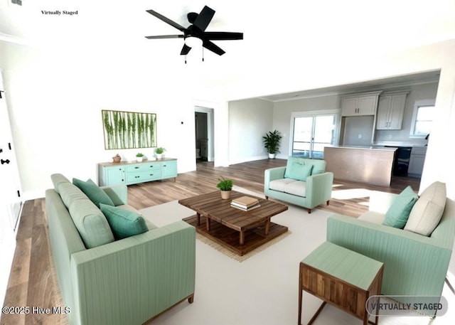 living area with visible vents, wood finished floors, and a ceiling fan