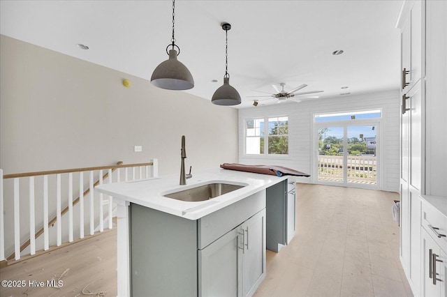 820 Kenneth Ave Unit 1, Carolina Beach, NC 28428 - kitchen with a sink, light wood-style floors, light countertops, a ceiling fan, and a center island with sink