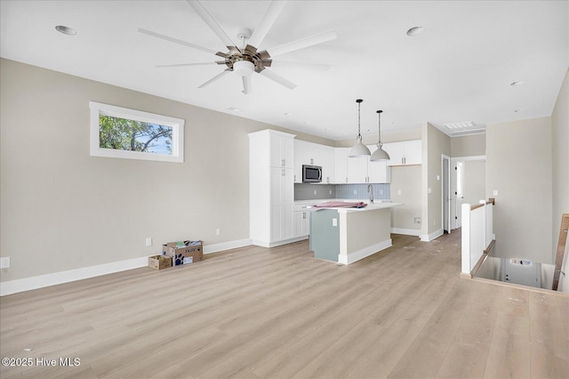 820 Kenneth Ave Unit 1, Carolina Beach, NC 28428 - unfurnished living room featuring a sink, baseboards, a ceiling fan, and light wood-type flooring