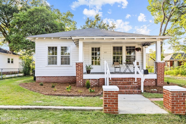 view of front of home with a front yard and a porch