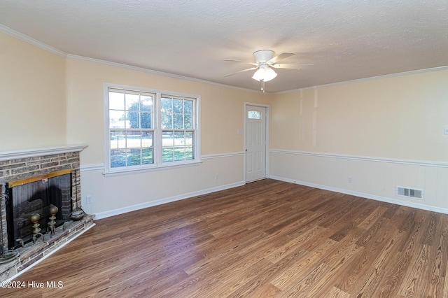 unfurnished living room with visible vents, a textured ceiling, wood finished floors, and a fireplace