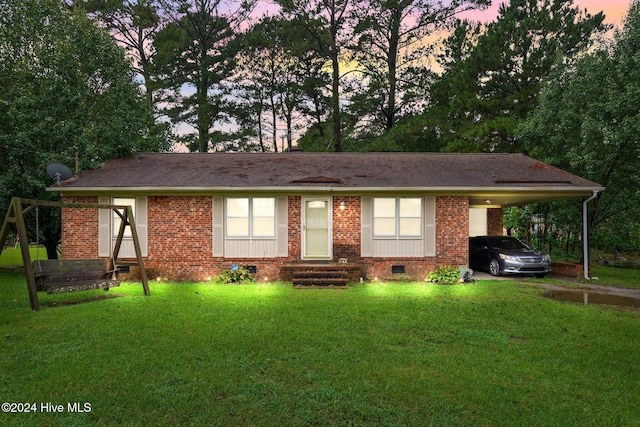 ranch-style house with brick siding, an attached carport, entry steps, a lawn, and crawl space