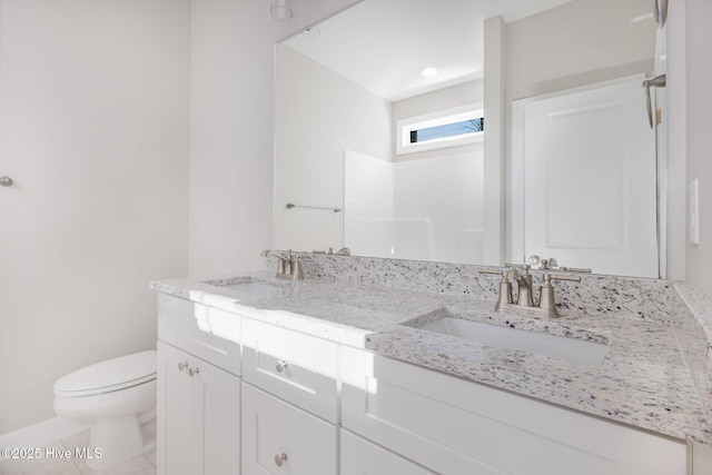 bathroom featuring vanity, tile patterned flooring, and toilet