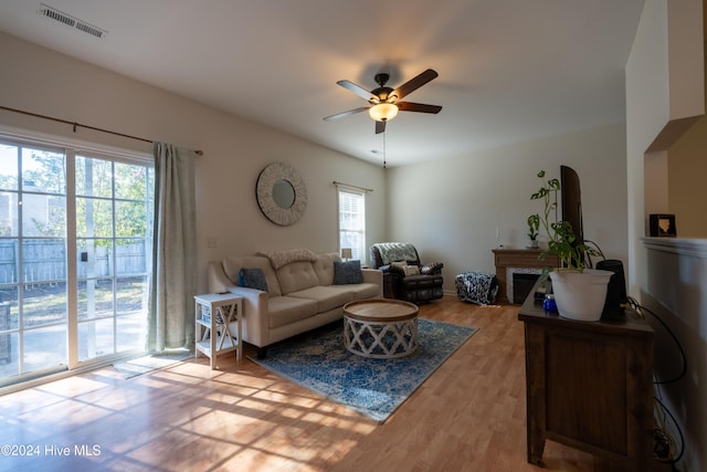 living room with wood-type flooring, a wealth of natural light, and ceiling fan