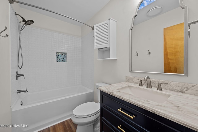 full bathroom featuring hardwood / wood-style floors, vanity, toilet, and tiled shower / bath