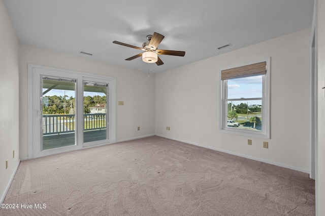 unfurnished room with light carpet, plenty of natural light, and ceiling fan