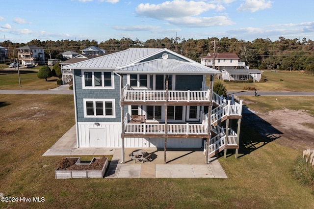 back of property with a lawn, a garage, and a balcony