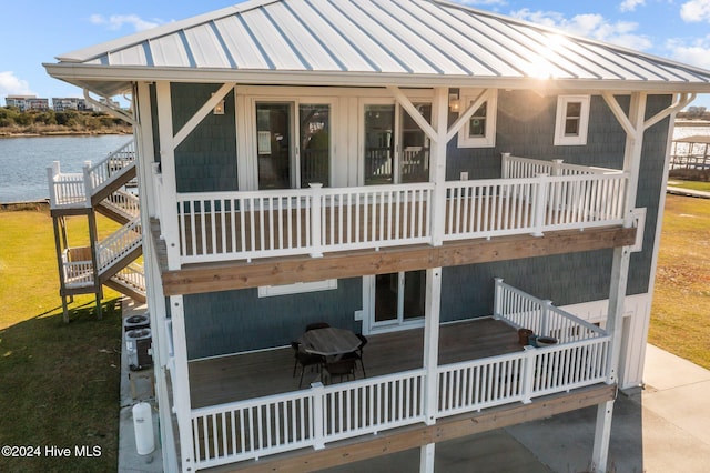 rear view of house with a deck with water view