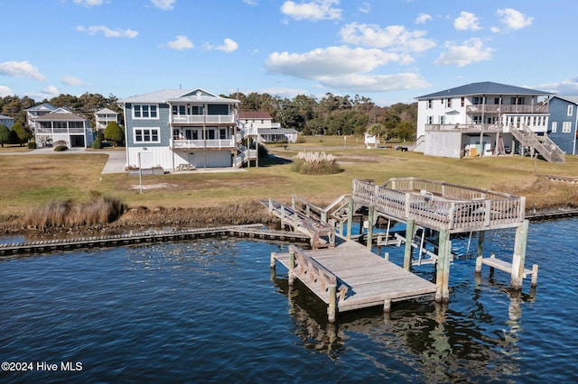 view of dock with a yard and a water view