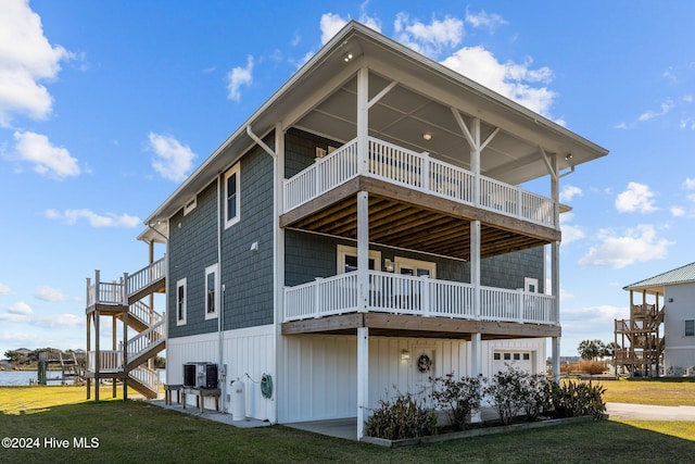 rear view of property featuring central air condition unit and a lawn