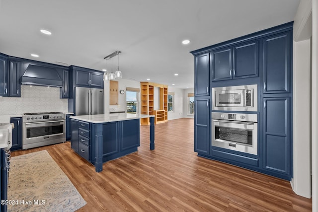 kitchen with premium range hood, blue cabinetry, a center island, and premium appliances