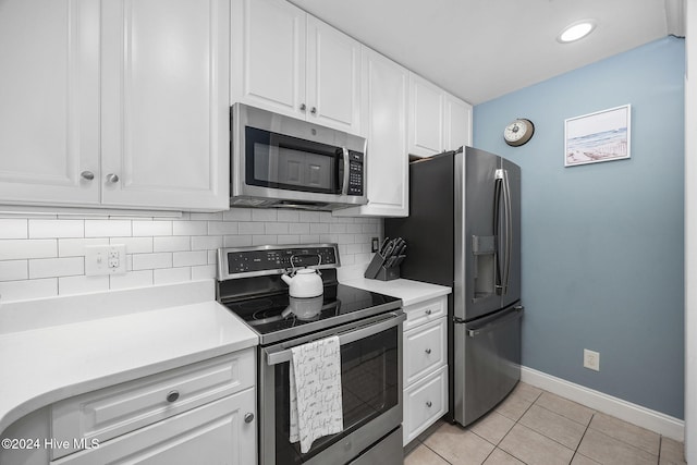 209 Hillside Dr N Unit 201, North Myrtle Beach, SC 29582 - kitchen with appliances with stainless steel finishes, white cabinetry, decorative backsplash, light countertops, and light tile patterned flooring