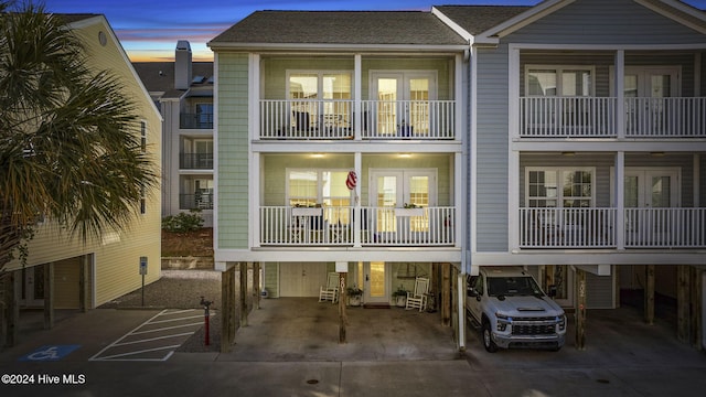 209 Hillside Dr N Unit 201, North Myrtle Beach, SC 29582 - rear view of house featuring concrete driveway, a carport, and a shingled roof