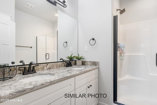 bathroom featuring walk in shower and vanity