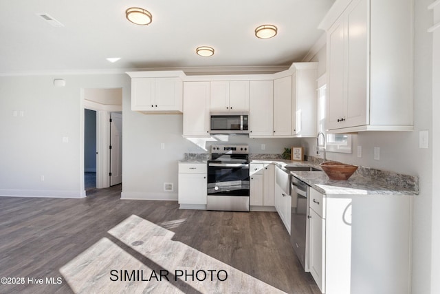 kitchen featuring crown molding, dark hardwood / wood-style flooring, stainless steel appliances, light stone countertops, and white cabinets