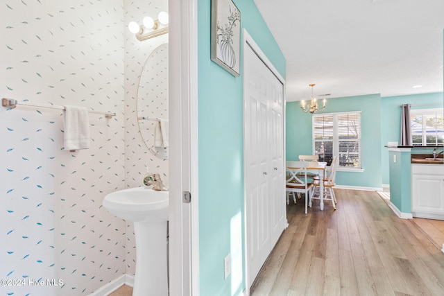 bathroom featuring hardwood / wood-style floors and an inviting chandelier