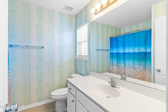 bathroom featuring tile patterned flooring, vanity, a textured ceiling, and toilet