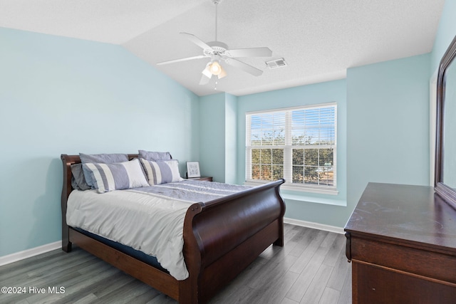 bedroom featuring a textured ceiling, dark hardwood / wood-style flooring, ceiling fan, and lofted ceiling