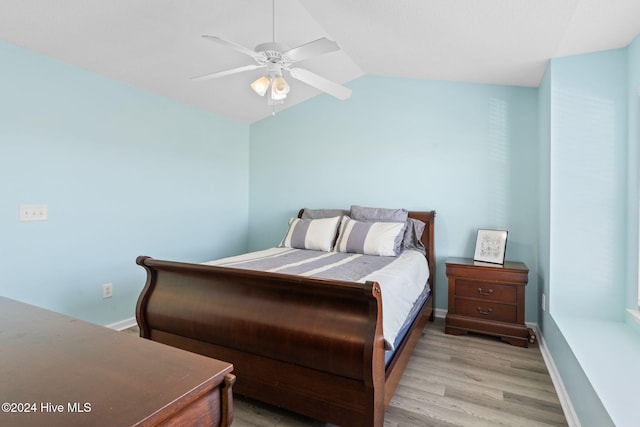 bedroom featuring ceiling fan, light hardwood / wood-style floors, and lofted ceiling