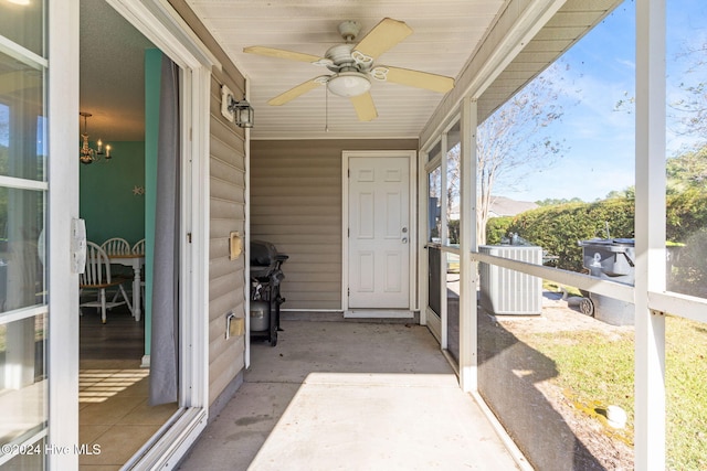 sunroom / solarium with ceiling fan with notable chandelier